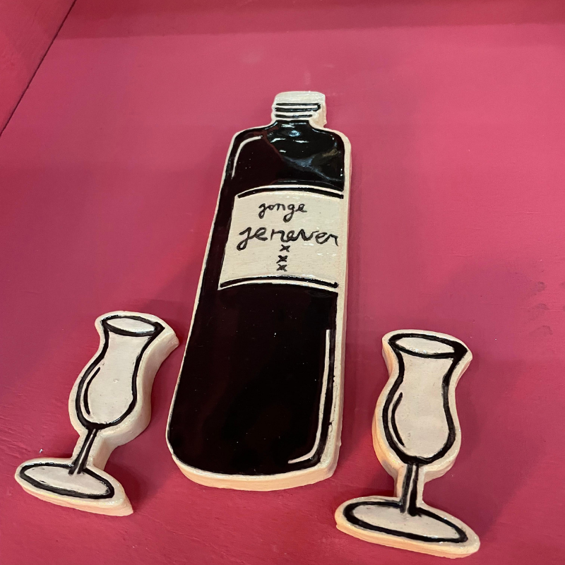Keramische fles jonge jenever met twee glaasjes op roze achtergrond