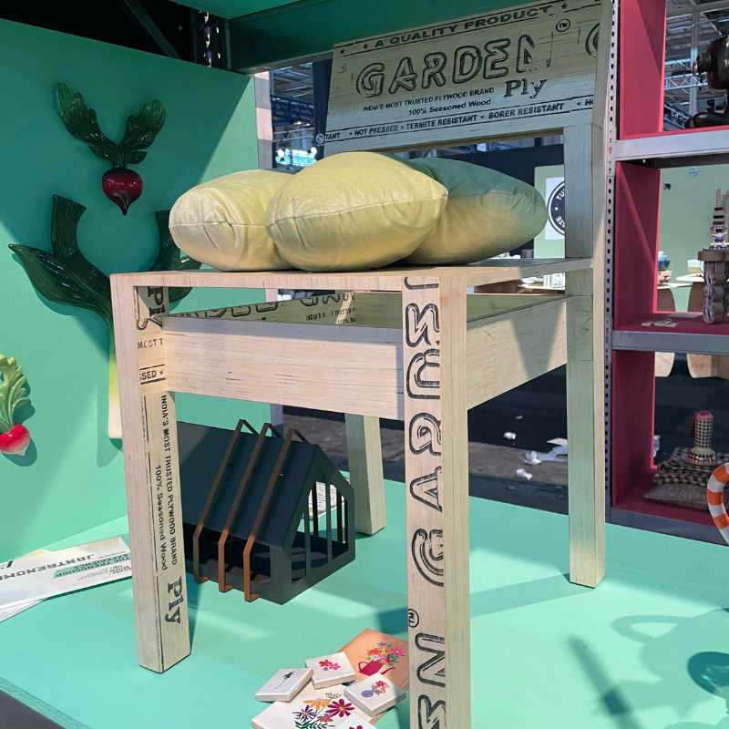 Houten tafel met drie groene kussens en lectuurbak