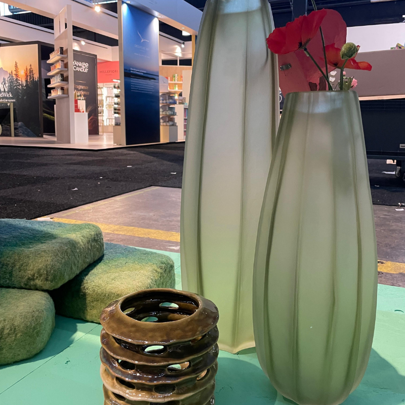 Groene vazen met rode bloemen op interieurbeurs