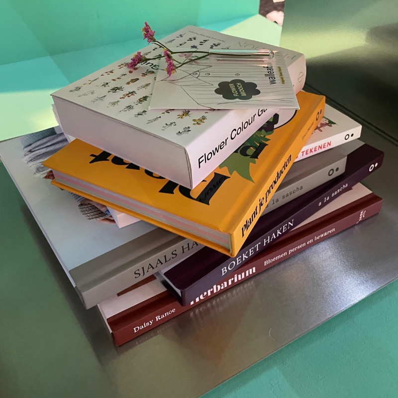 Stapel bloemenboeken met gedroogde bloem en pen