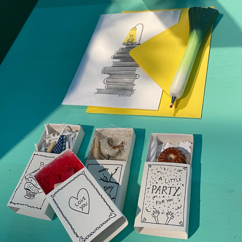 Handgemaakte cadeauverpakkingen, kaarten en pen op turquoise tafel