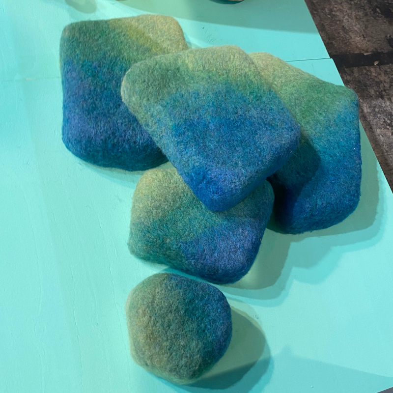 Stapeling van vijf blauwgroene vilten stenen