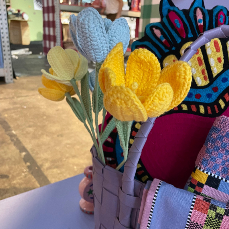 Gehaakte tulpen in mandje naast kleurrijke textielpop