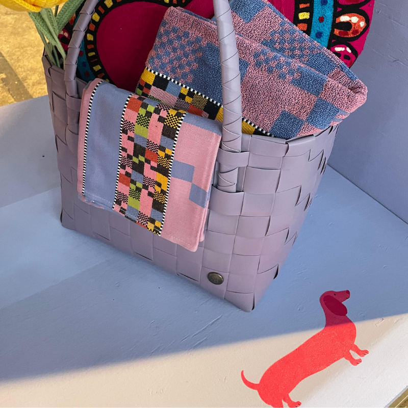 Lila gevlochten tas met kleurrijke handdoeken