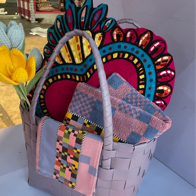 Lila mand met kleurrijke textielkunst en gehaakte bloemen