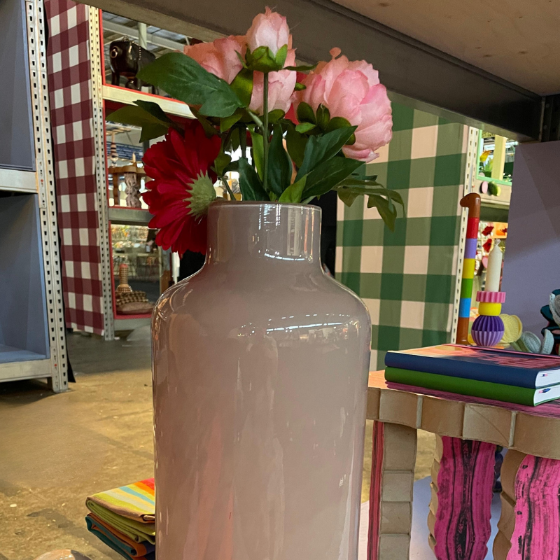 Roze vaas met pioenrozen en rode gerbera in winkel