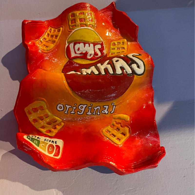 Rode kunstsculptuur van een Lay's Max-zak chips