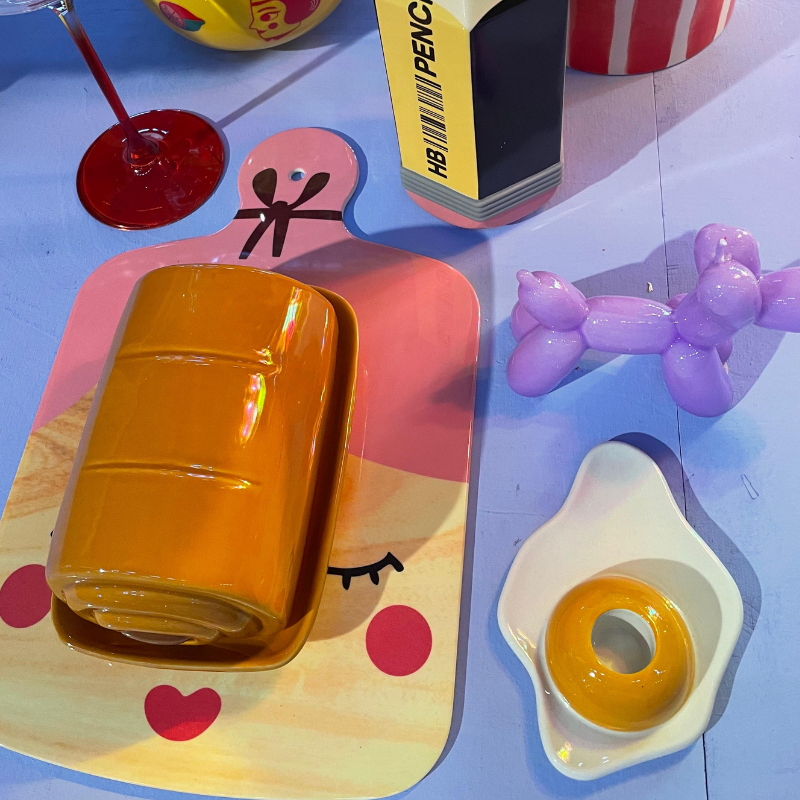 Oranje glazen boterdoos op kleurrijke tafel