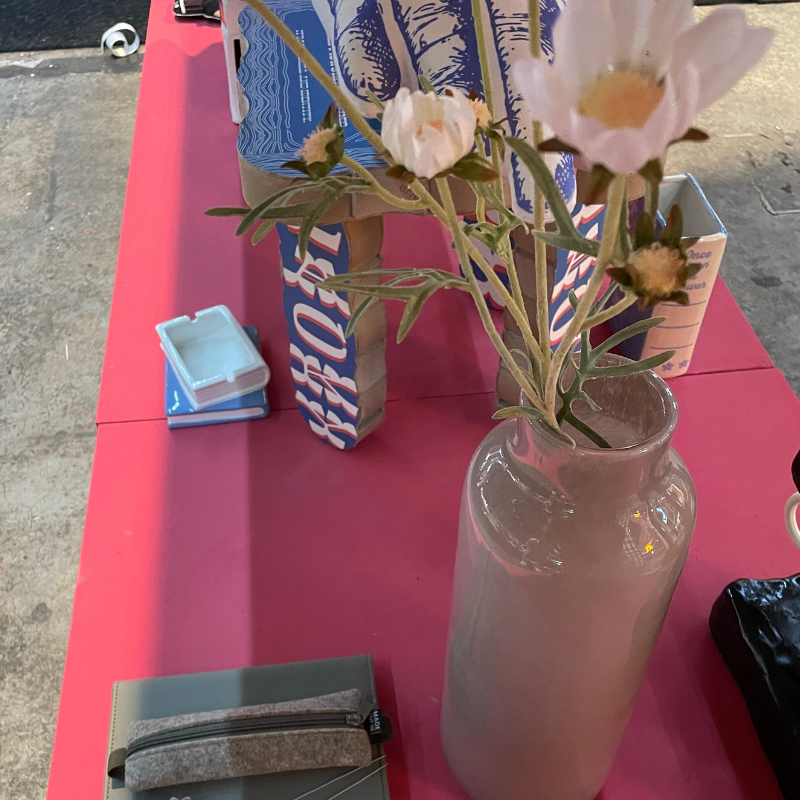 Roze bloemen in glazen vaas op roze tafel