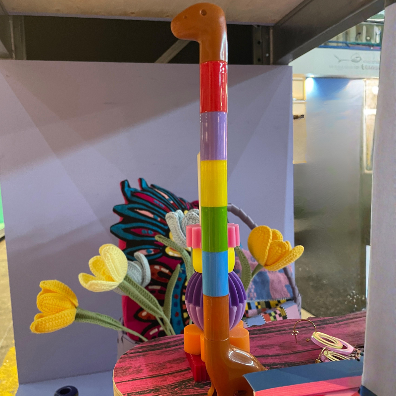 Kleurrijke speelgoedwandelstok tussen gehaakte bloemen op een display