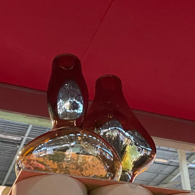 Twee glanzende glazen flessen van onderaf gefotografeerd