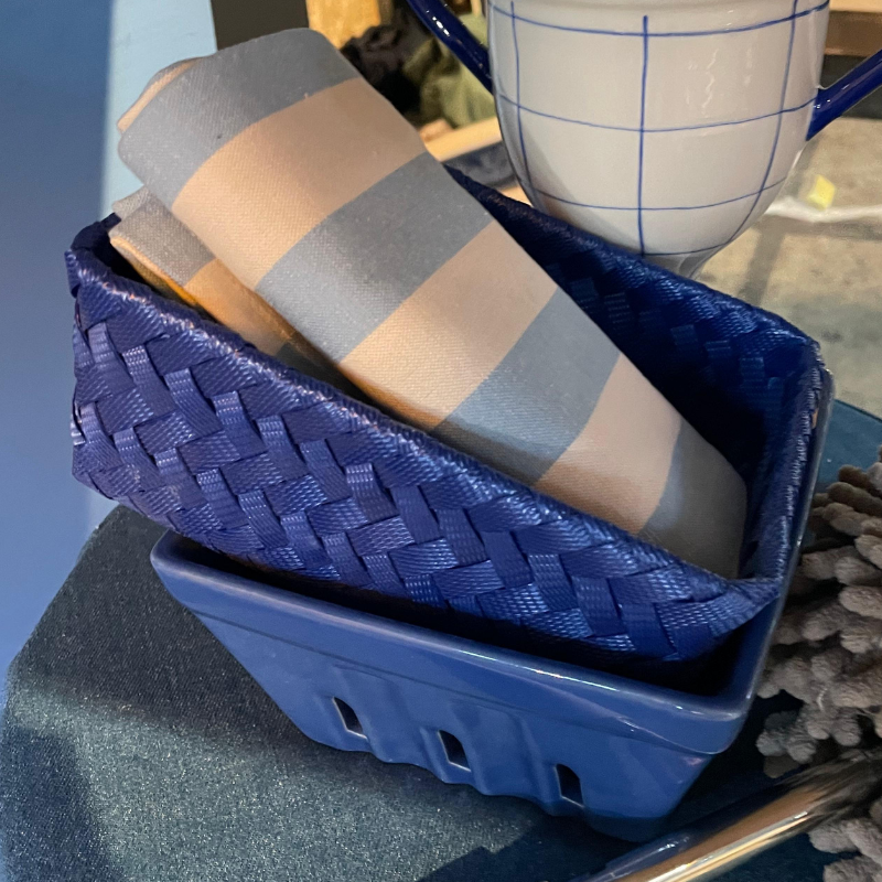 Blauw mandje met gestreepte servetten en geruite mok