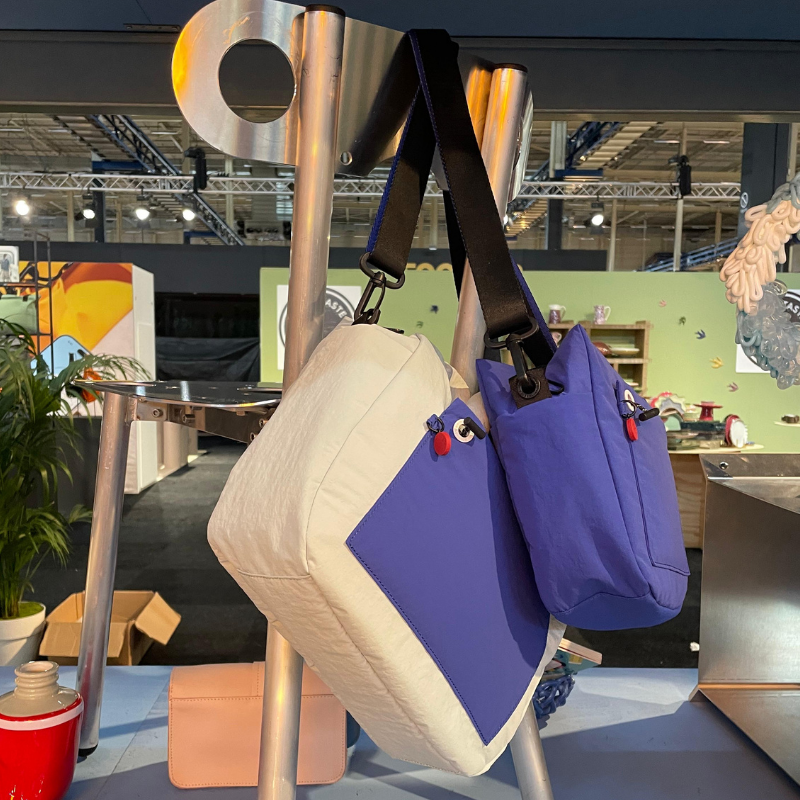 Twee kleurrijke tassen hangen aan metalen display