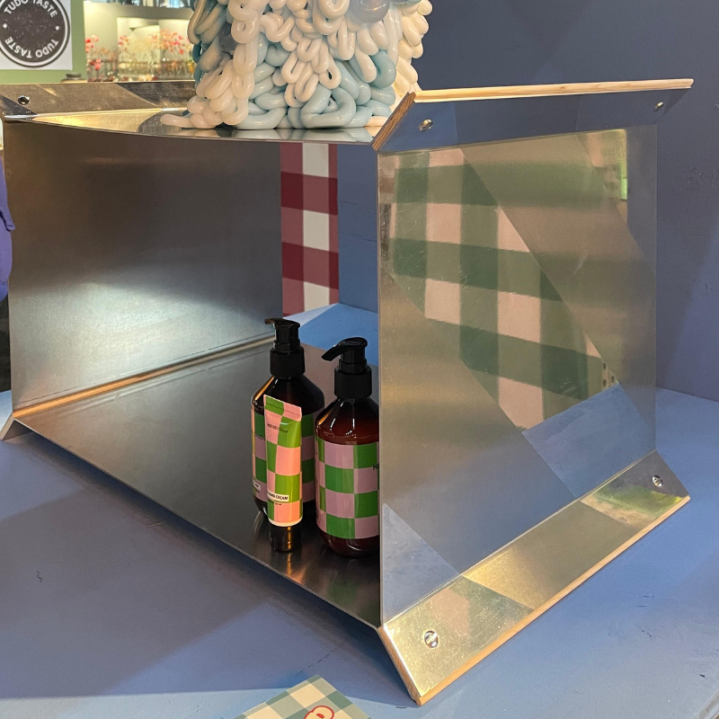 Twee pompflessen in metalen display met geruit patroon
