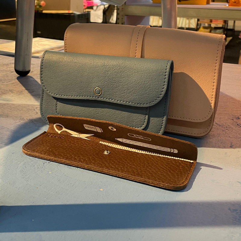 Drie leren hoesjes voor manicuregereedschap op tafel