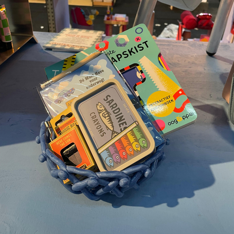 Blauwe mand met kleurrijke creatieve kinderproducten