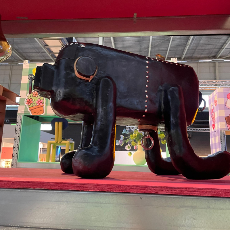 Zwart dierlijk kunstobject op rode sokkel in tentoonstellingshal