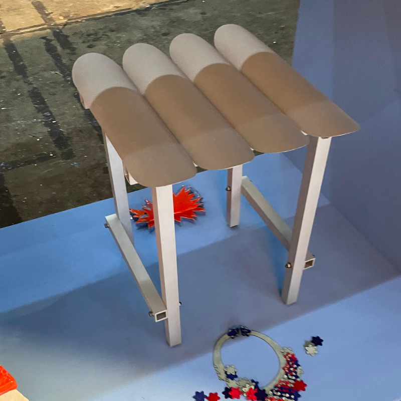 Miniatuurtafel met vier gebogen, tweekleurige bovenpanelen.