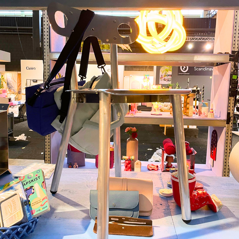 Metalen standaard met tas en felgele neonlamp