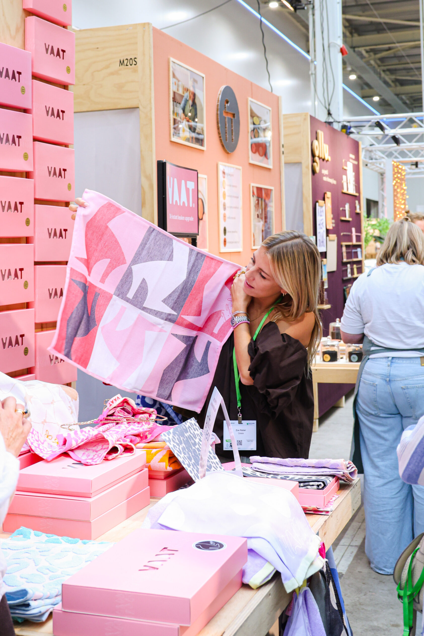 Bezoeker bekijkt kleurrijke handdoek bij VAAT-stand