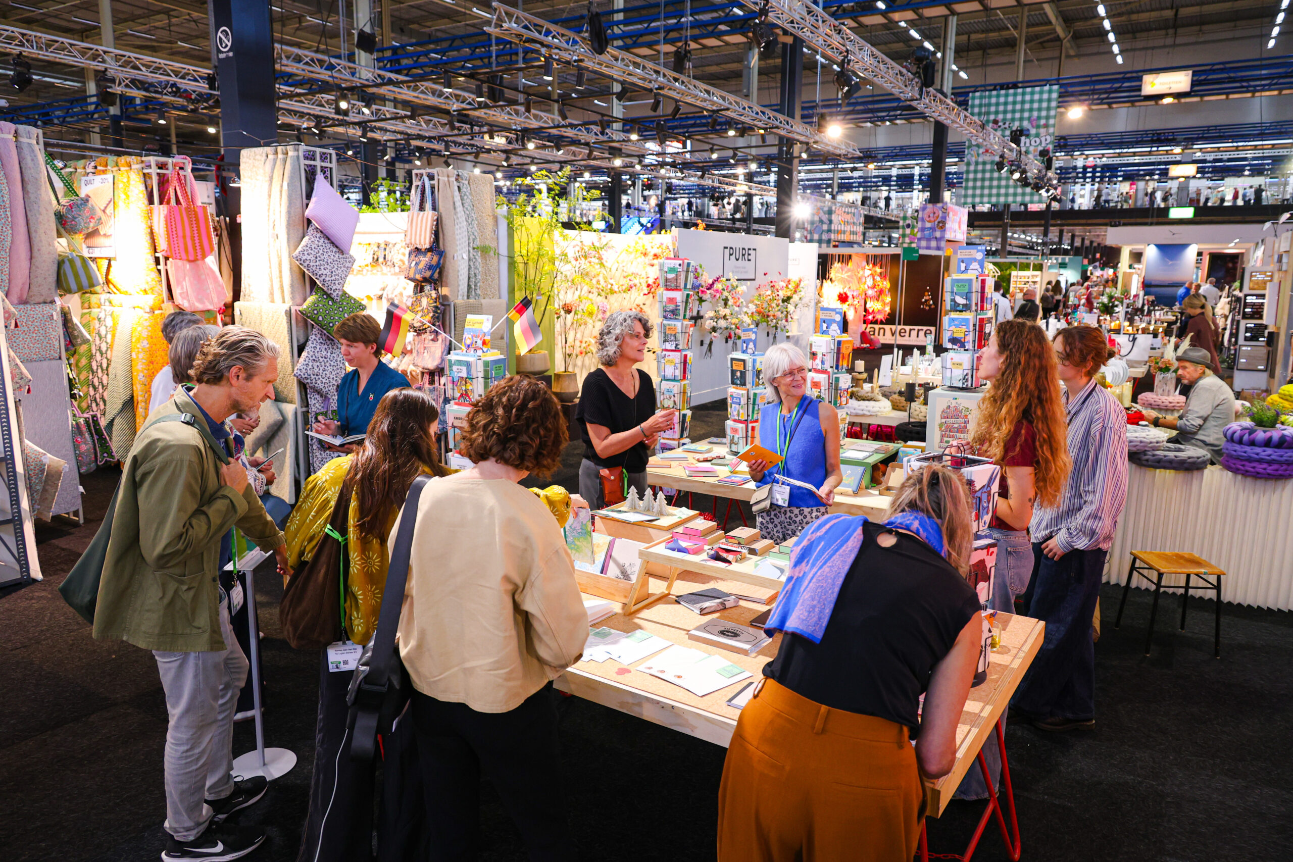Bezoekers bladeren door boeken op een drukke beurs
