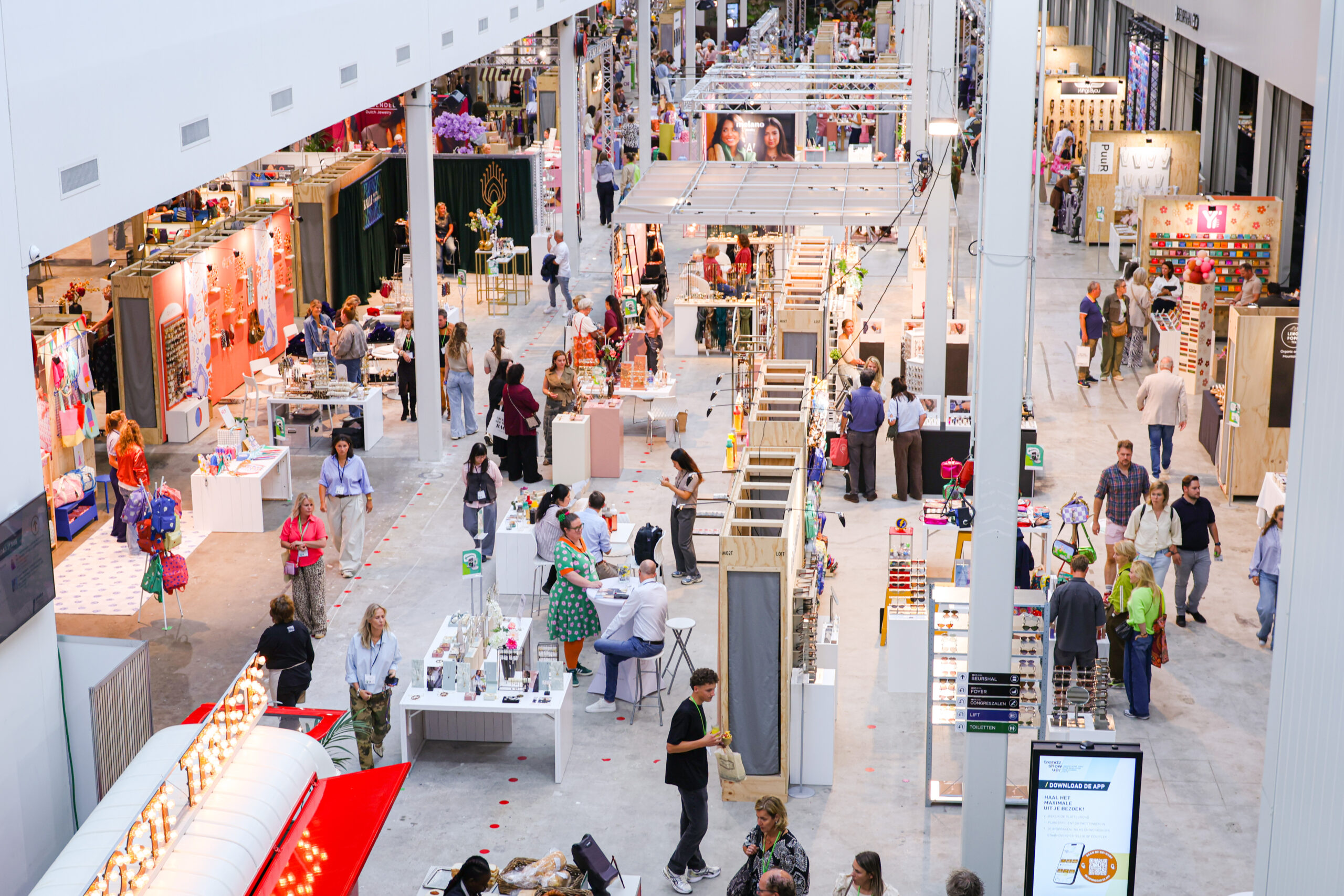 Drukke beursvloer met bezoekers en stands in evenementenhal