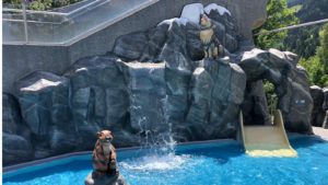 Kinderbad, met glijbaan, en verschillende objecten, compleet met rots-achterwand en waterval.