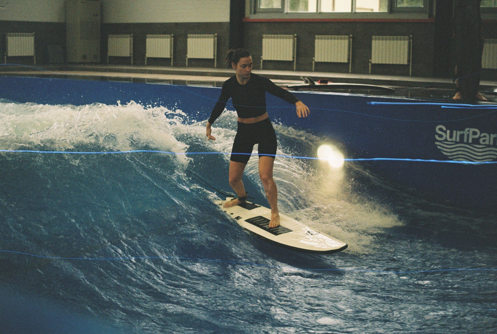 Surfer rijdt op kunstmatige golf in een binnenbad