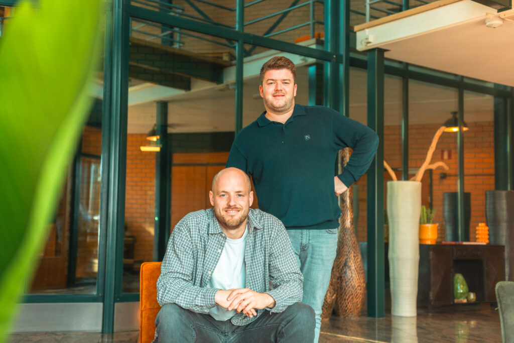 Twee mannen poseren in een modern kantoor