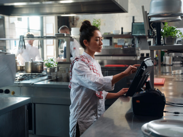 Kok voert bestelling in op kassascherm in restaurantkeuken