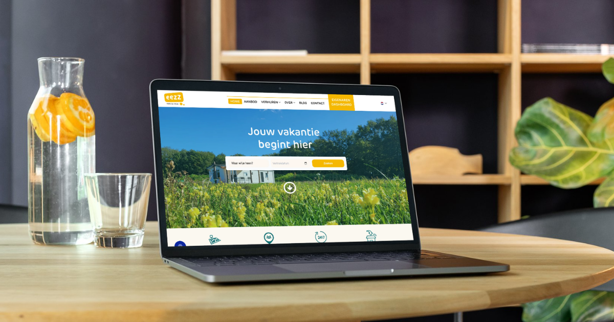 Laptop toont Nederlandse vakantieboekingswebsite op houten tafel