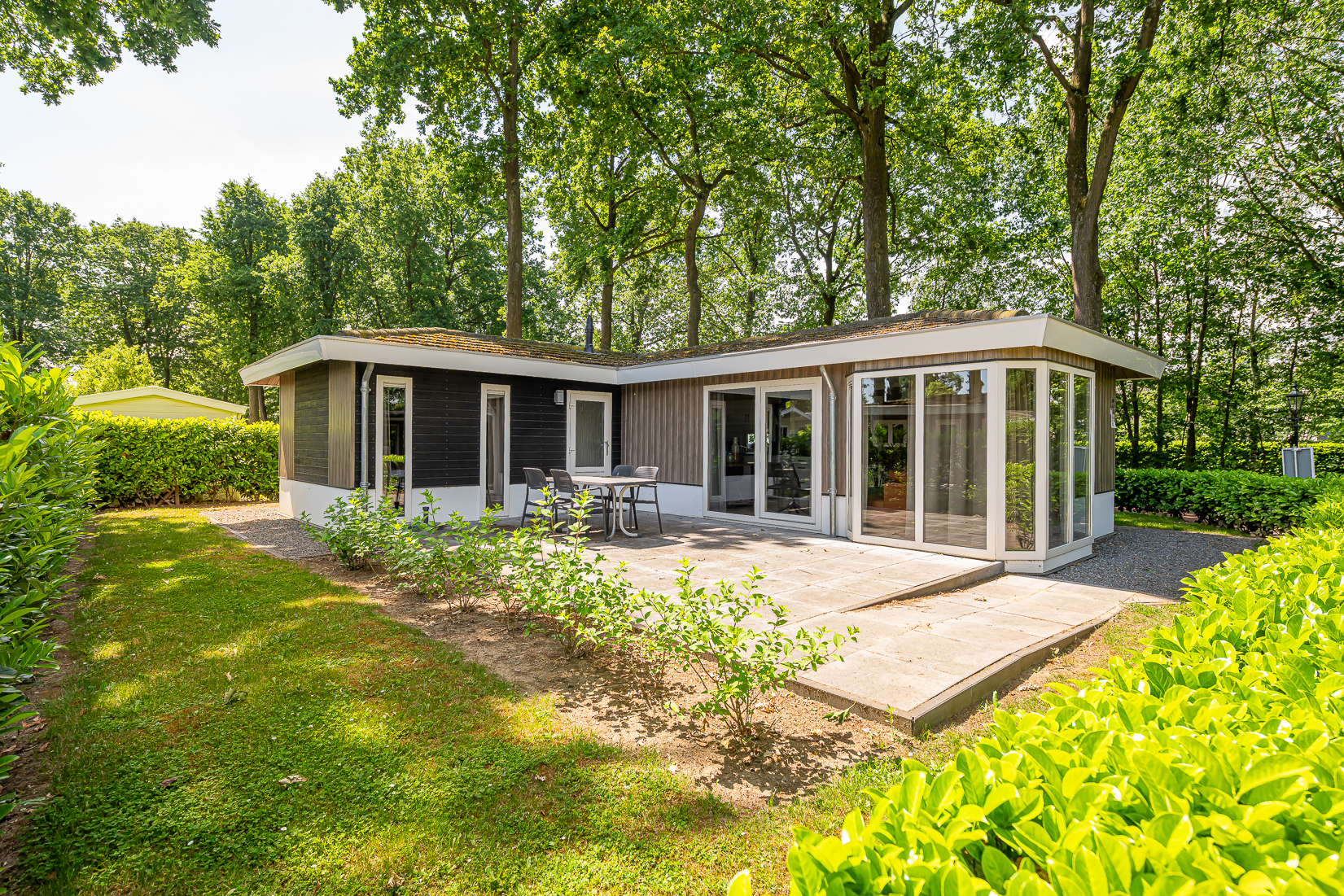 Vrijstaande vakantiewoning met terras tussen hoge bomen
