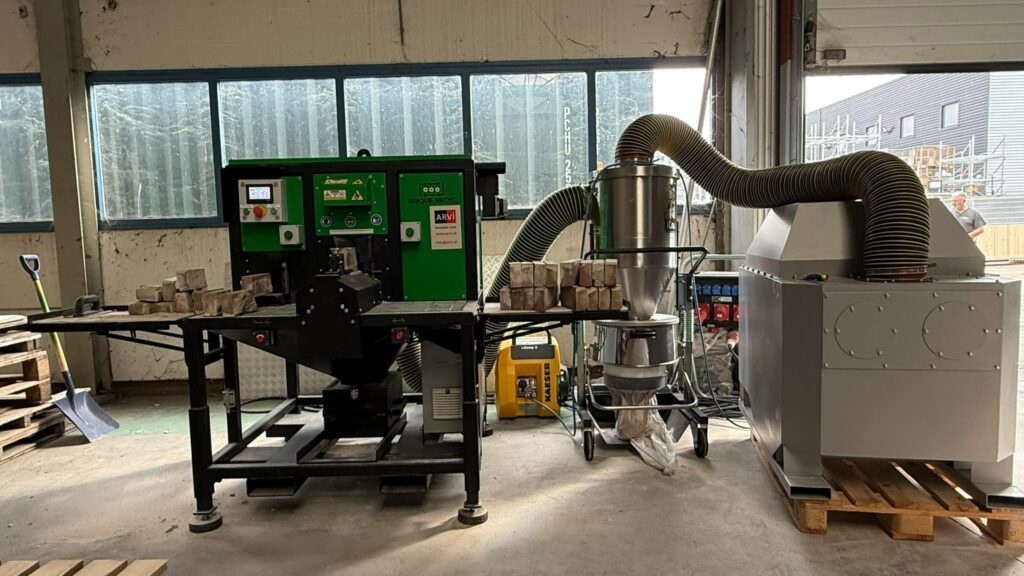Machine voor brikettenproductie met afzuiginstallatie in werkplaats