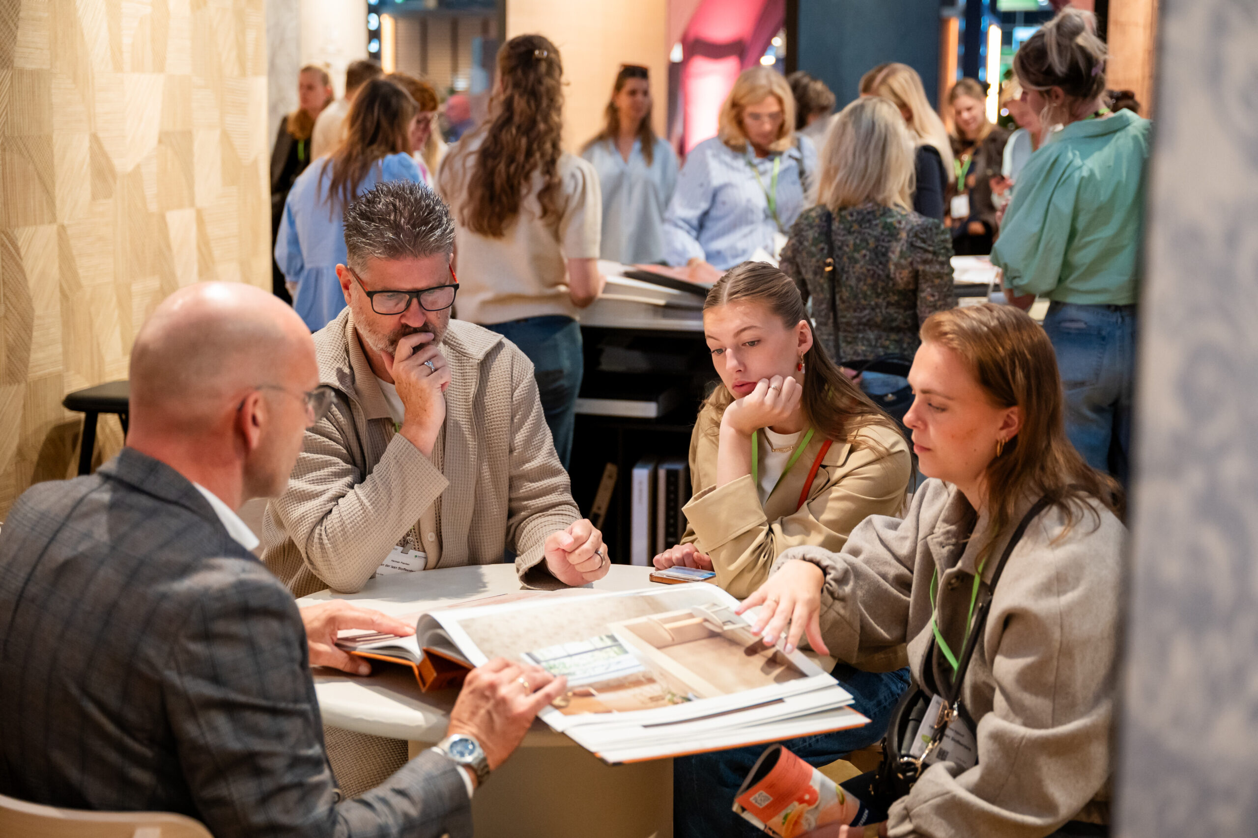 Bezoekers bespreken catalogi tijdens een druk netwerkevenement