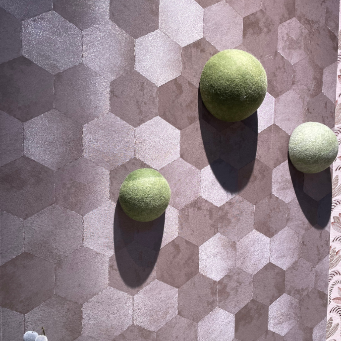 Drie groene bollen op grijze hexagonale wand