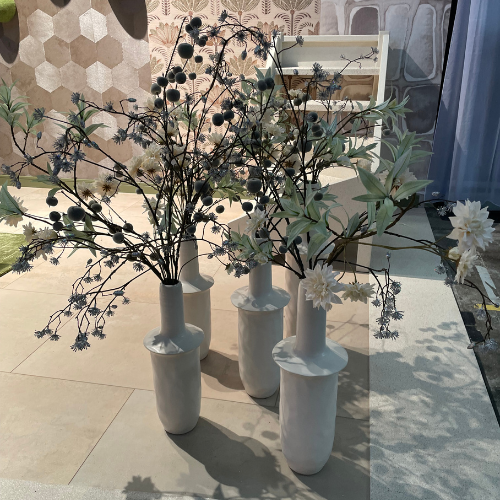 Droogbloemen in witte vazen op tegelvloer