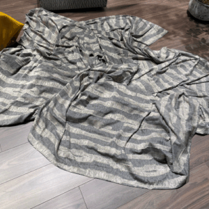 Grijze gestreepte plaid op donkere houten vloer