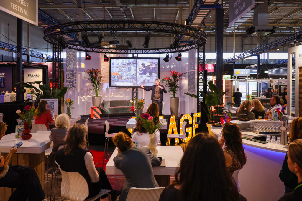 Spreker presenteert op interieurbeurs voor zittend publiek