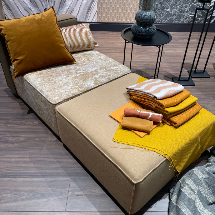 Beige chaise longue met okergele kussens en plaids