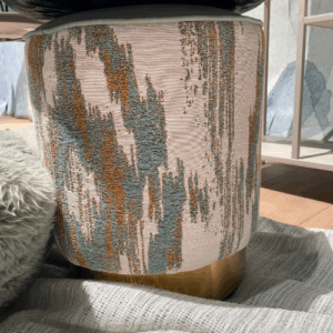 Gestoffeerde poef met abstract patroon en gouden voet
