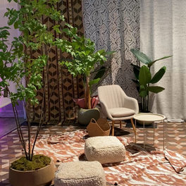 Sfeervolle zithoek met fauteuil, planten en ronde tafeltjes