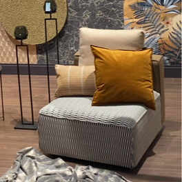 Moderne fauteuil met okerkleurige kussens en voetenbank