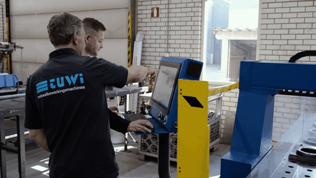 Twee medewerkers bedienen een industriële metaalbewerkingsmachine