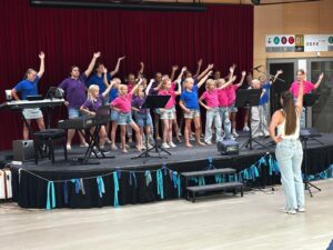 Kinderkoor zingt op podium onder leiding van dirigent
