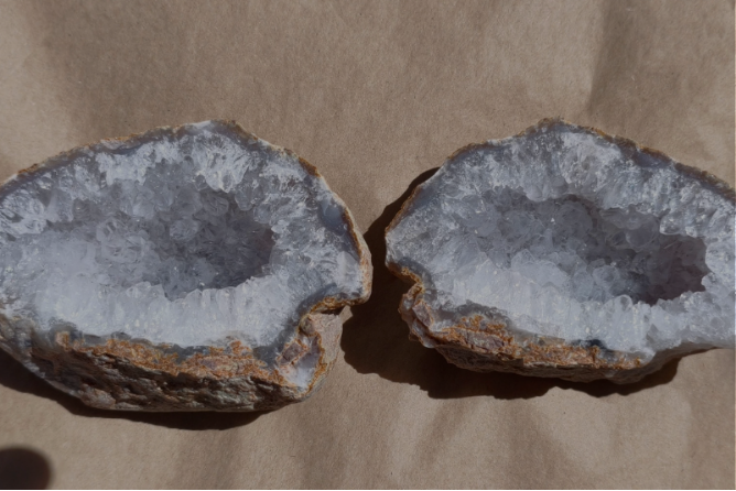 Twee helften van een geode met grijze kristallen