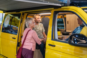 lachende bezoekers op zoek naar camperbusje