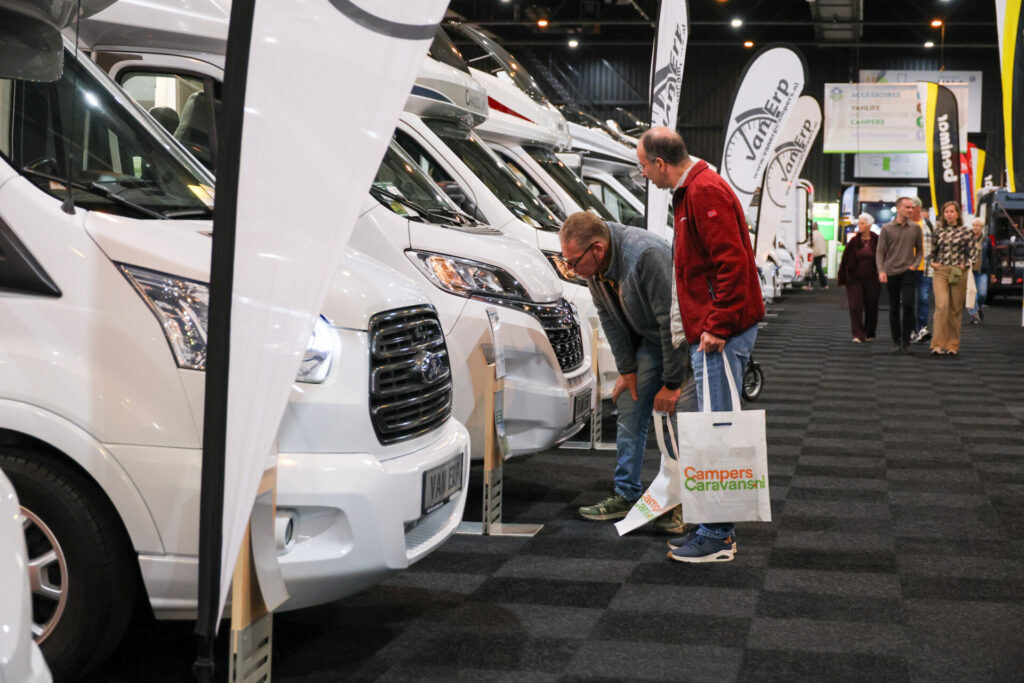 Bezoekers bekijken campers op een beurs