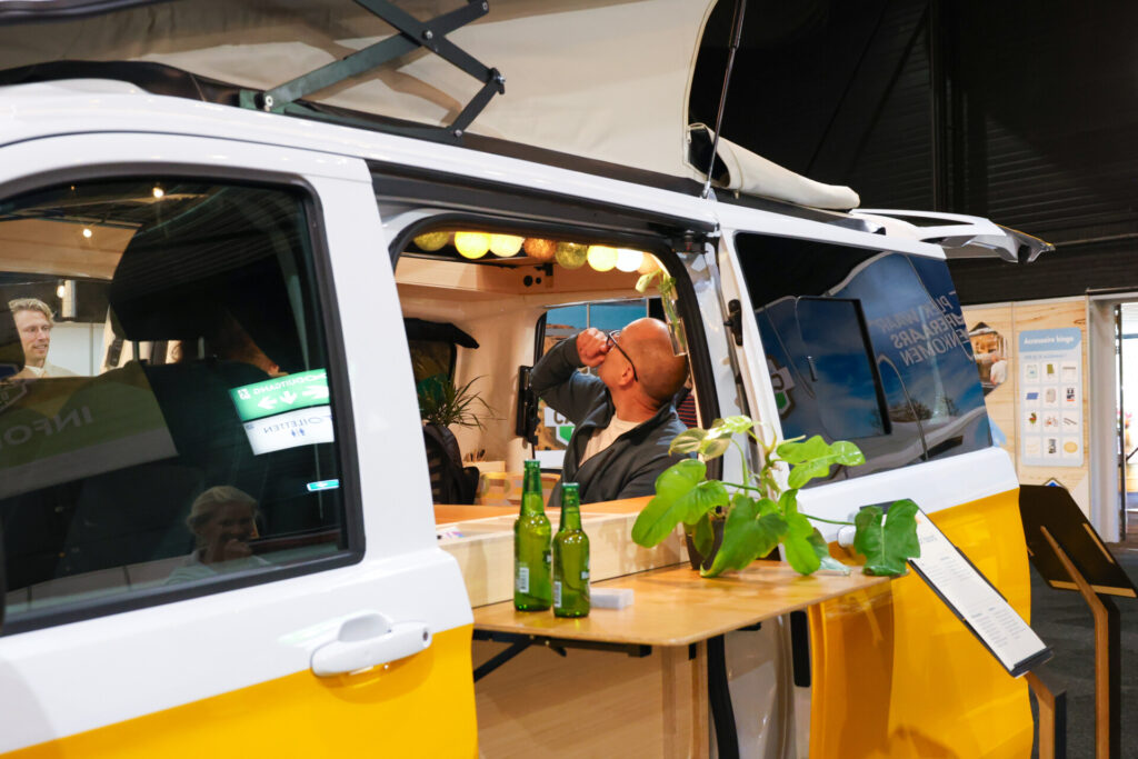 Man bekijkt hefdak van gele camperbus
