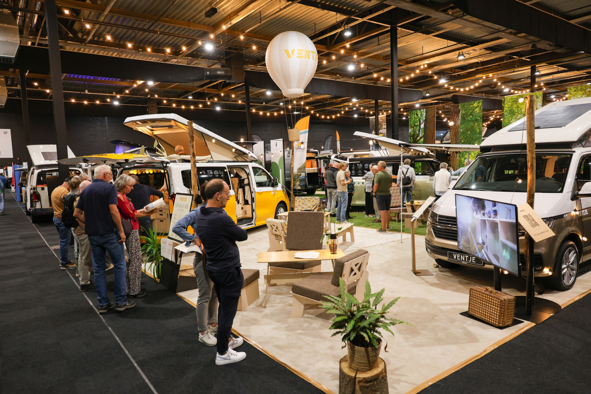 Bezoekers bekijken Ventje-campers op een beurs