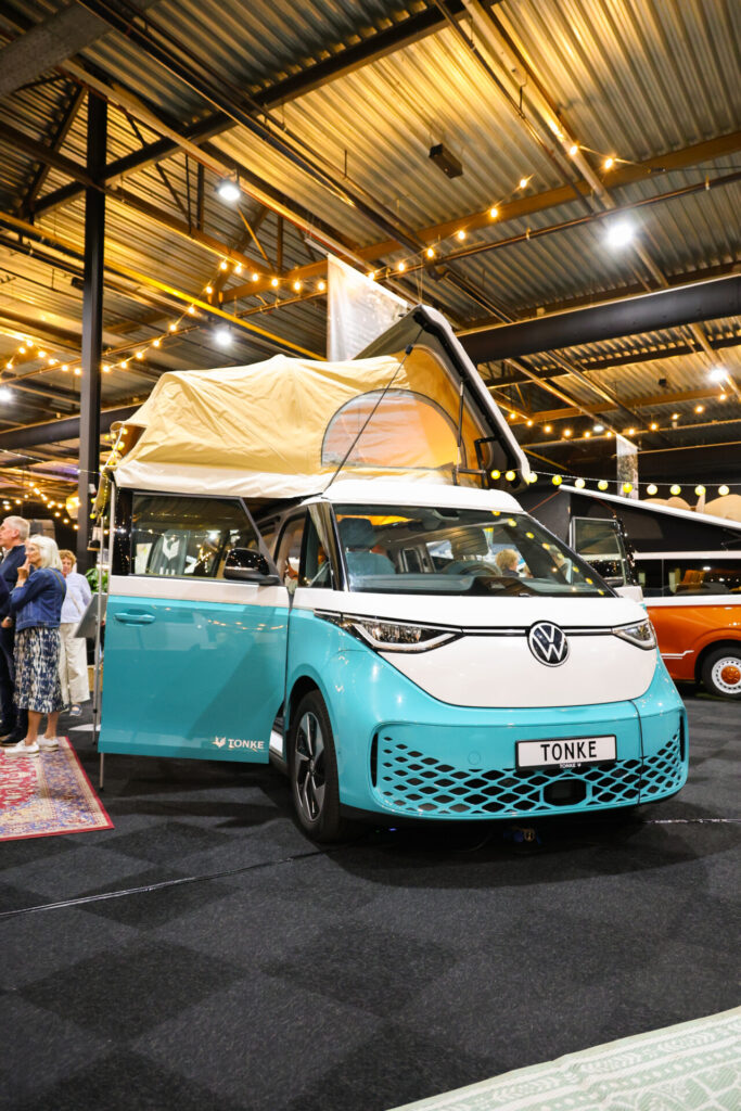 Turquoise Volkswagen ID. Buzz met hefdak op beurs